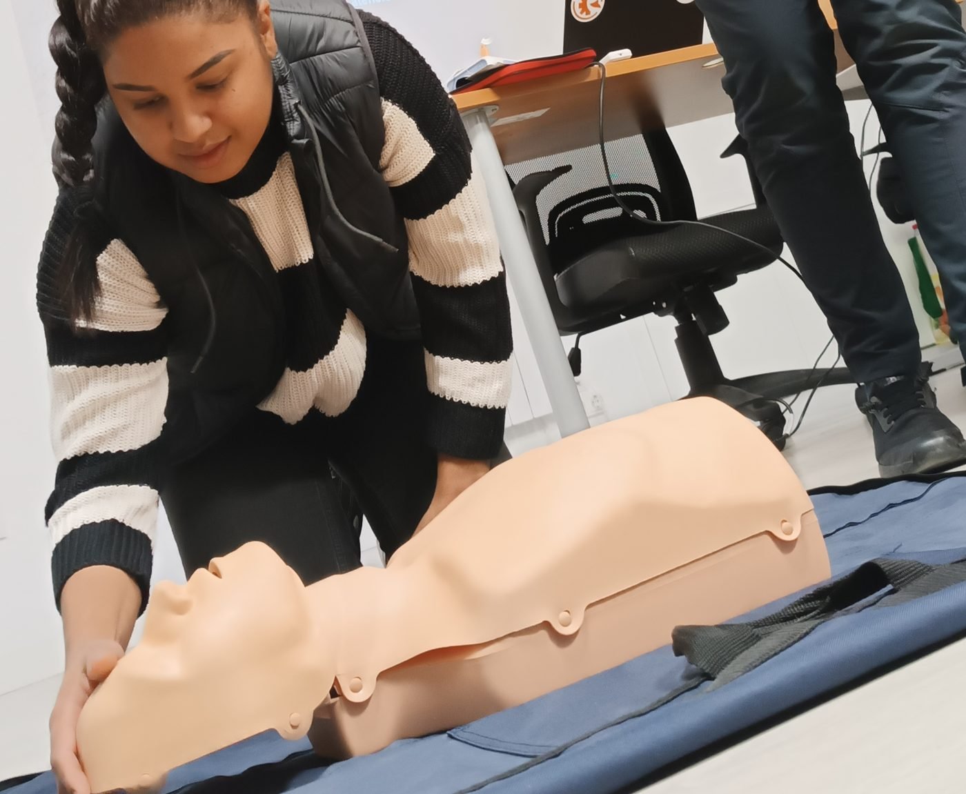 Alumna practicando reanimación cardiopulmonar sobre maniquí