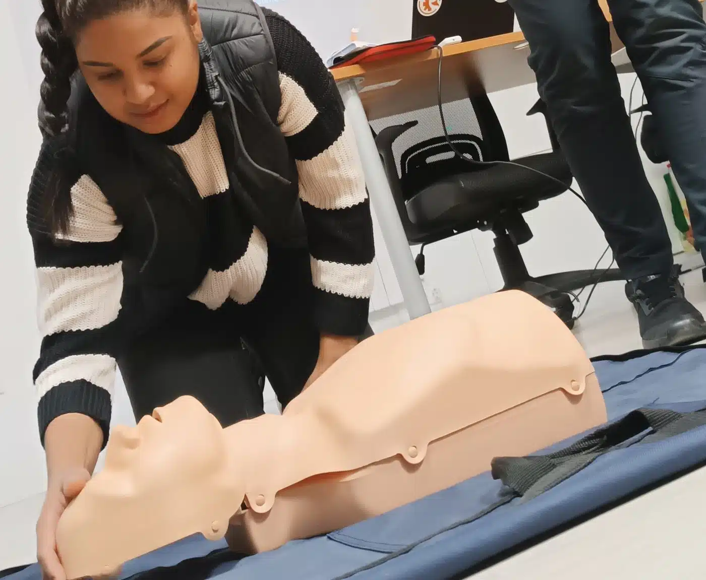 Alumna practicando reanimación cardiopulmonar sobre maniquí