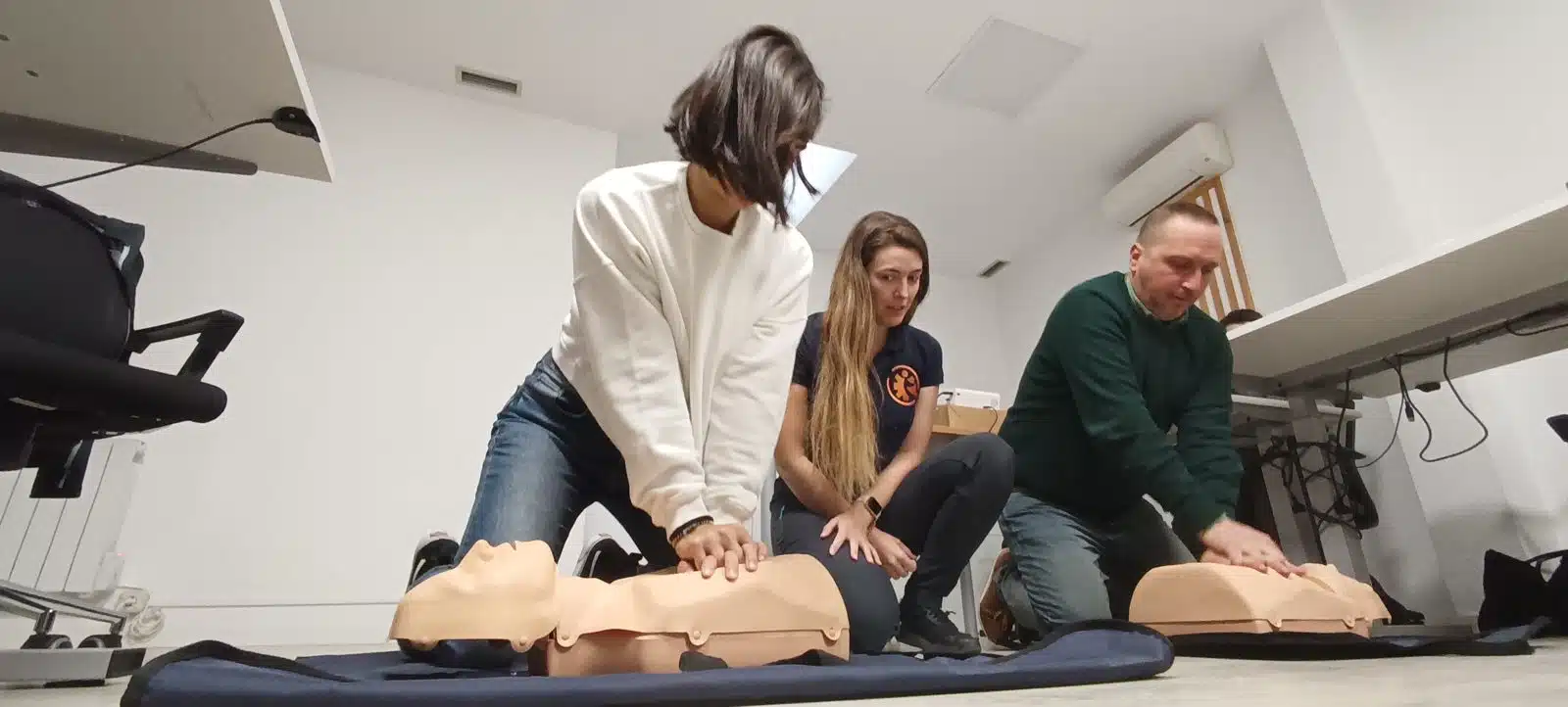 Alumnos practicando RCP con maniquís en el curso