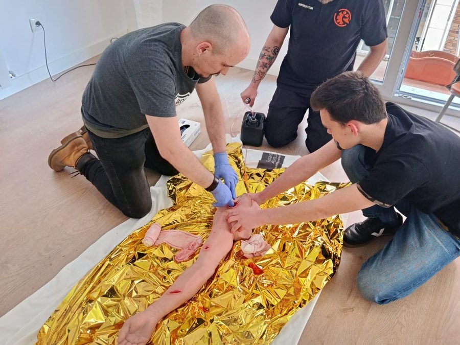 Grupo practicando atención a un herido con manta térmica