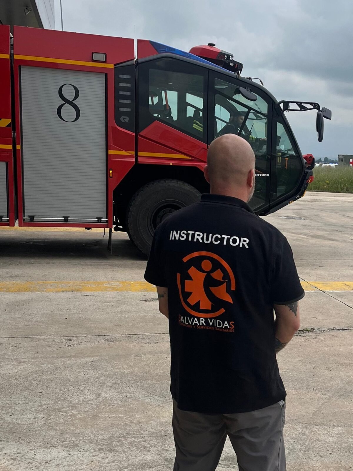 Instructor de Salvar Vidas junto a camión SSEI de bomberos de aeropuerto