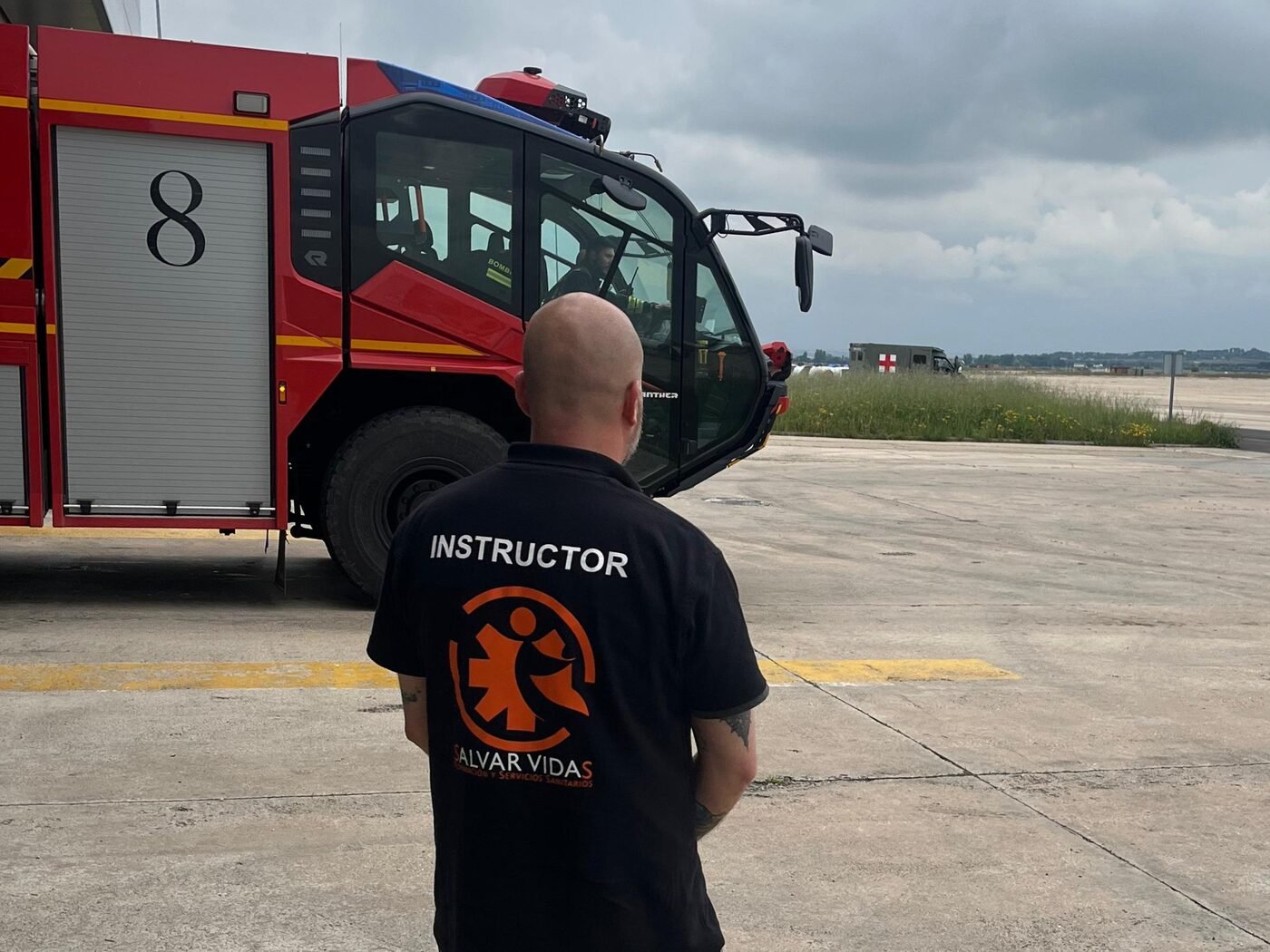 Formación en emergencias aeroportuarias — instructor Salvar Vidas ante camión SSEI