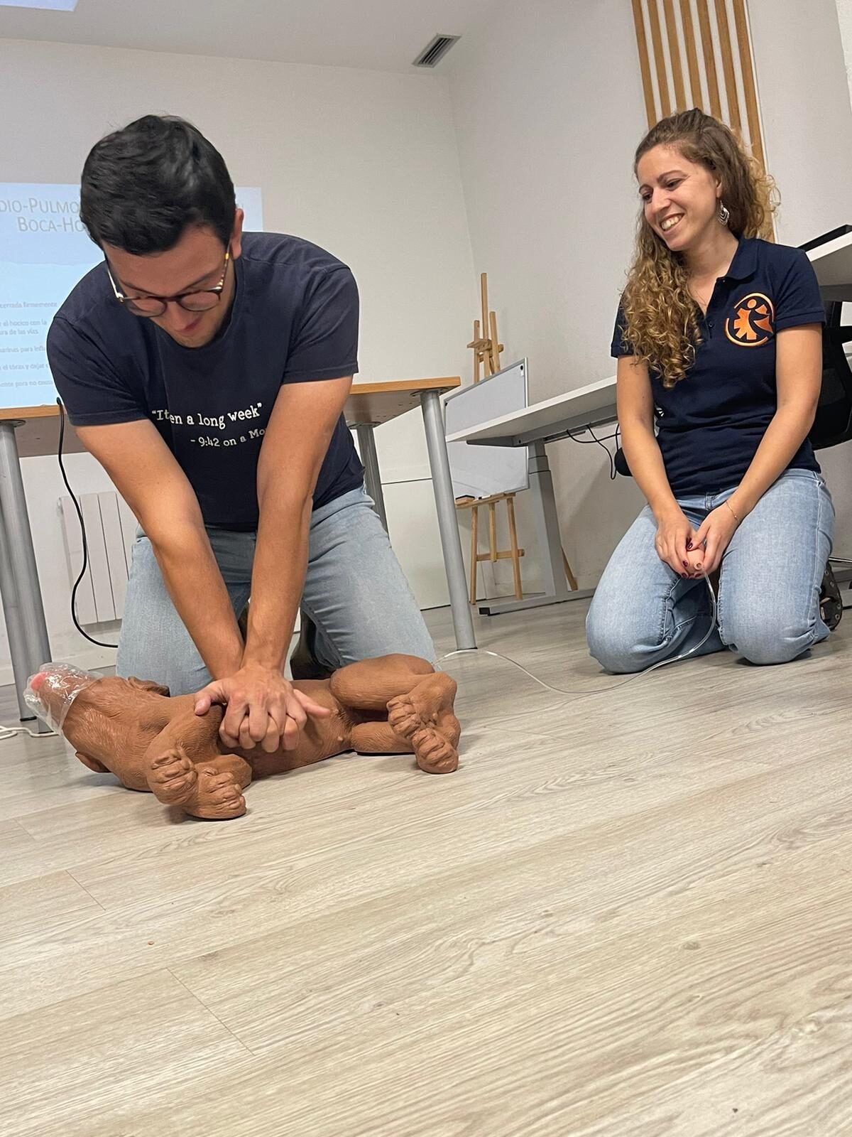 Pareja practicando RCP en un maniquí de mascota