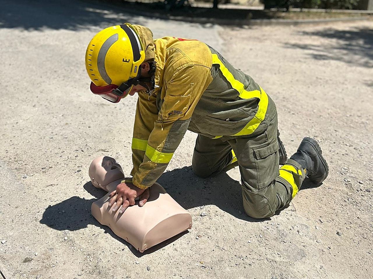 Bombero forestal practicando compresiones de RCP sobre un maniqui en un curso de SVB y DESA de Salvar Vidas