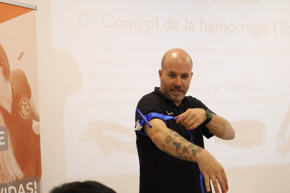 Instructor de Salvar Vidas colocando un torniquete en el brazo durante un curso de control de hemorragias