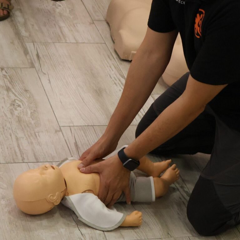 Instructor practicando compresiones torácicas con un maniquí de bebé