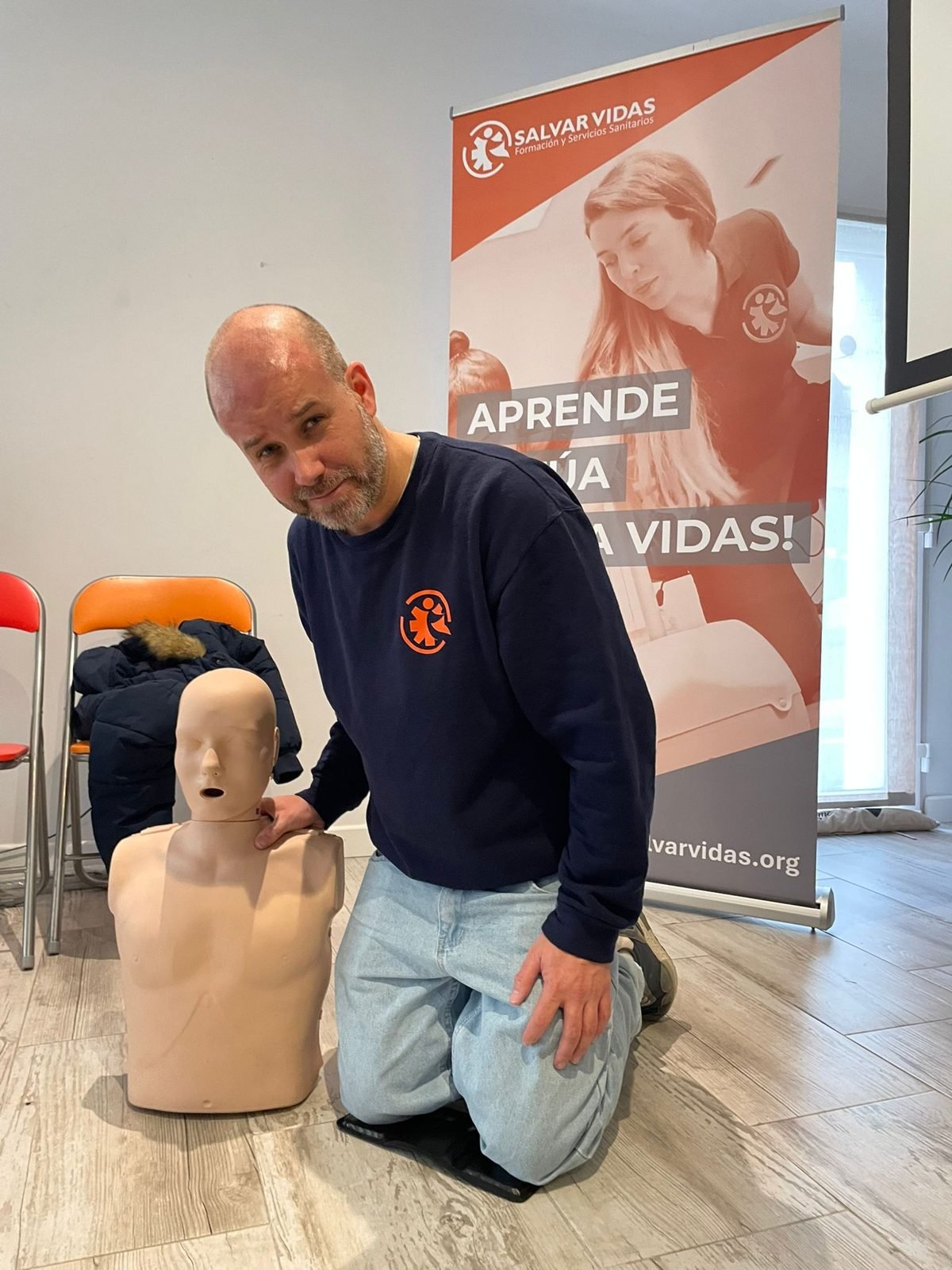 Instructor de Salvar Vidas junto a un maniquí de RCP de adulto