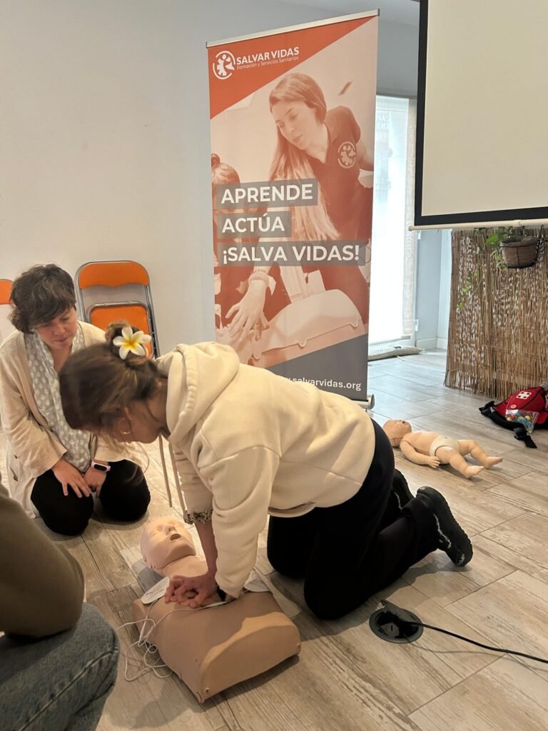 Alumna practicando RCP en un maniquí de adulto en el curso de primeros auxilios de Madrid